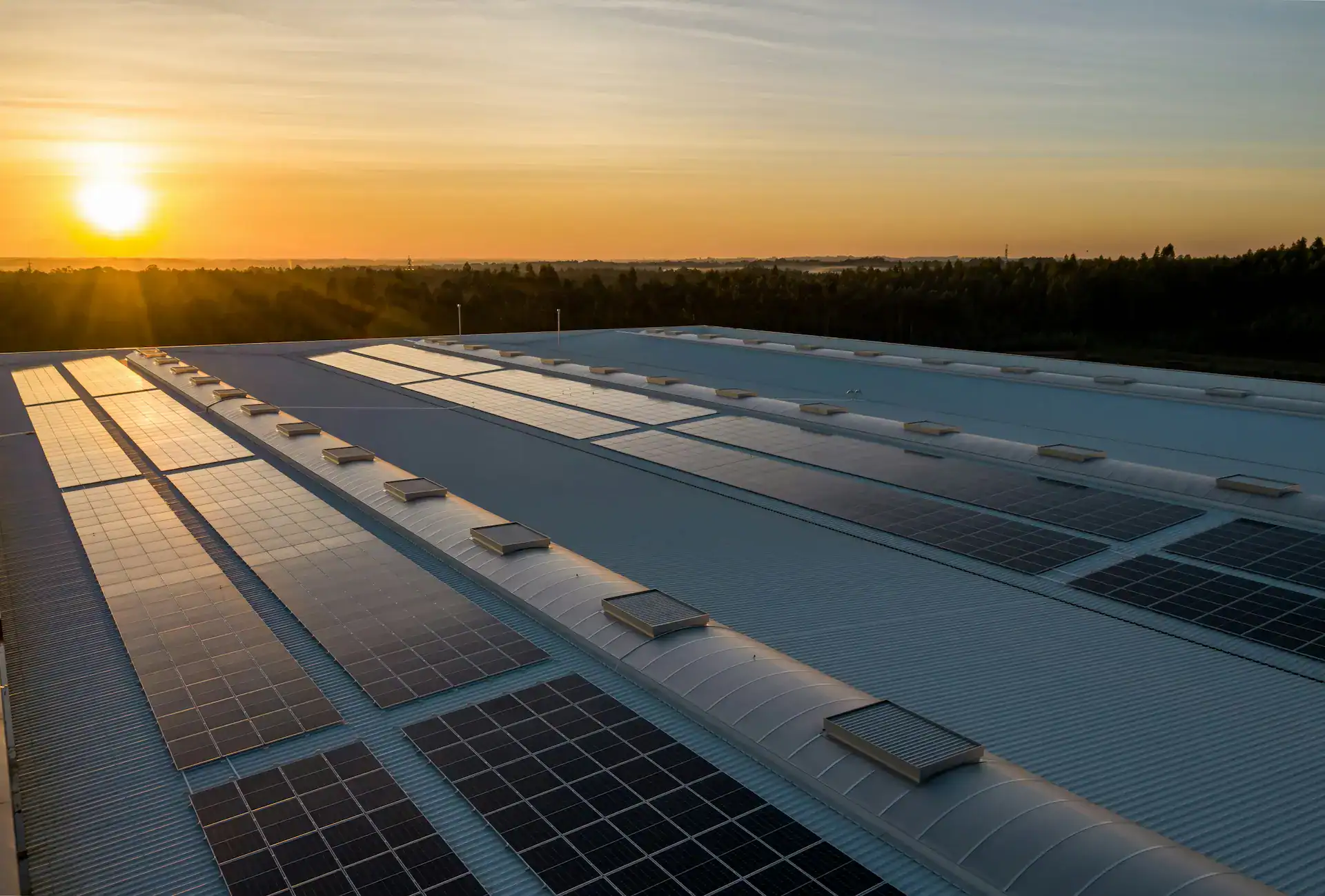 Solaranlagen auf Industriedach bei Sonnenuntergang