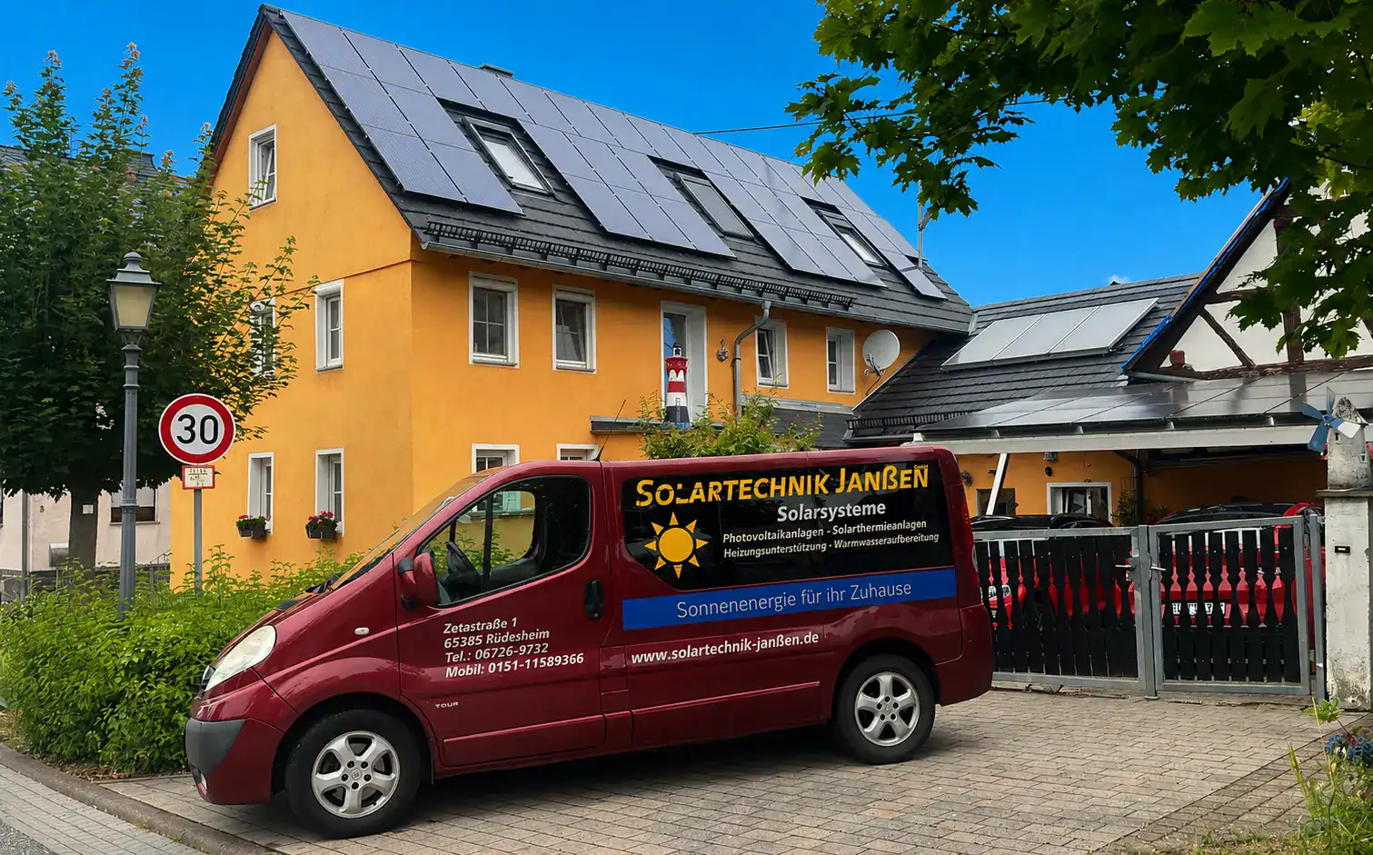 Einfamilienhaus mit Solaranlage und Firmenwagen davor