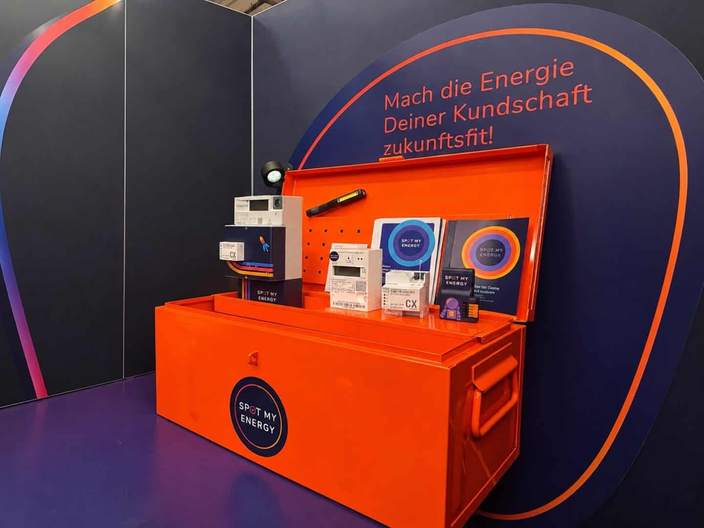 Orange Werkzeugkiste mit Energiezählern auf Messestand